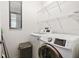 Bright laundry room with modern washer and dryer, white wire rack shelving, and natural light at 1306 Harbor Ridge Dr, Kissimmee, FL 34759