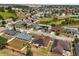 This aerial view showcases a residential neighborhood with solar panels, well-maintained lawns, and a pond in the background at 131 Highland Meadows Pl, Davenport, FL 33837
