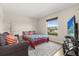 Cozy bedroom features a gray sofa, television, area rug and a large window view at 131 Highland Meadows Pl, Davenport, FL 33837