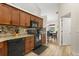 Well-lit kitchen featuring wooden cabinetry, black appliances, and mosaic backsplash, open to the dining area at 131 Highland Meadows Pl, Davenport, FL 33837