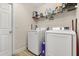 Functional laundry room featuring a washer, dryer, and shelving for storage at 131 Highland Meadows Pl, Davenport, FL 33837