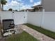 Well-maintained backyard featuring a white fence, brick pathway, and lush green grass, offering a private outdoor space at 1505 Chevington Ct, Orlando, FL 32824