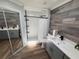 Modern bathroom featuring a walk-in shower, wood accent wall, gray vanity and quartz countertop at 1505 Chevington Ct, Orlando, FL 32824
