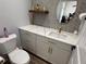 Powder room featuring a modern quartz countertop vanity with gold hardware and a round mirror at 1505 Chevington Ct, Orlando, FL 32824