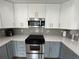 Updated kitchen with stainless steel appliances, gray backsplash and countertops, and ample cabinet space at 1505 Chevington Ct, Orlando, FL 32824