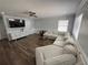 Spacious living room with large sectional sofa, entertainment center, and a ceiling fan at 1505 Chevington Ct, Orlando, FL 32824