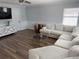 Comfortable living room with a large sectional sofa, modern entertainment center, and wood-look floors at 1505 Chevington Ct, Orlando, FL 32824