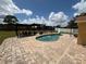 Stunning pool area featuring an inviting pool, brick pavers, and a charming pergola with outdoor furniture at 1505 Chevington Ct, Orlando, FL 32824