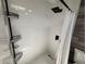 Modern shower with white tiles, black shower head and shelving, and a clear glass door at 1505 Chevington Ct, Orlando, FL 32824