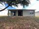 Back exterior of home showing covered patio with sliding glass doors and a grassy area at 15408 Groose Point Ln, Clermont, FL 34714