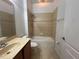 Bright bathroom features a shower-tub combo with tile surround and a warm-toned vanity at 15408 Groose Point Ln, Clermont, FL 34714