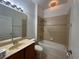 Bright bathroom features a vanity with sink, tub, shower, and decorative tile at 15408 Groose Point Ln, Clermont, FL 34714