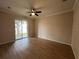 Bright bedroom with modern ceiling fan, wood floors, and sliding glass door to the exterior at 15408 Groose Point Ln, Clermont, FL 34714