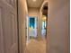 Long hallway with neutral paint and ceramic tile, leading to other rooms in the home at 15408 Groose Point Ln, Clermont, FL 34714