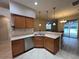 Kitchen sink area with stainless steel dishwasher and wood cabinets at 15408 Groose Point Ln, Clermont, FL 34714