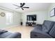 Spacious living room featuring tile floors, a ceiling fan, and a large television at 156 Bristol Forest Trl, Sanford, FL 32771