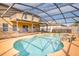 Backyard oasis featuring an in-ground pool with a spa and rock accents, enclosed by a screen at 156 Bristol Forest Trl, Sanford, FL 32771
