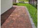 Brick paved patio with green grass, surrounded by black aluminum fence at 15929 Moonlight Bay St, Winter Garden, FL 34787