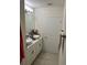 Bright bathroom with and sinks, white cabinets, white walls and white tile floors at 15929 Moonlight Bay St, Winter Garden, FL 34787