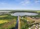 Wide aerial shot of the property, highlighting the serene lake, canal, and the vast green landscape surrounding it at 1626 Salmon St, St Cloud, FL 34771
