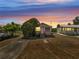 Charming single-story home with a mature tree, pictured at sunset at 1626 Salmon St, St Cloud, FL 34771