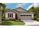 Charming single-story home featuring stone accents, red shutters, and a two-car garage at 175 Flag Lilly Ln, Umatilla, FL 32784