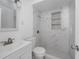 Bright bathroom featuring tiled shower with built-in shelving and modern sink and toilet at 1814 Leroy Dr, Haines City, FL 33844