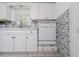 Clean kitchen with white cabinets, tile backsplash, and bright lighting under the window at 1814 Leroy Dr, Haines City, FL 33844