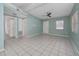 A spacious living room with ceramic tile floors, light blue walls, a ceiling fan, and abundant natural light at 1814 Leroy Dr, Haines City, FL 33844