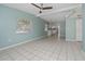 A spacious living room with ceramic tile floors, light blue walls, a ceiling fan, and abundant natural light at 1814 Leroy Dr, Haines City, FL 33844