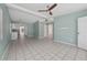 A spacious living room with ceramic tile floors, light blue walls, a ceiling fan, and abundant natural light at 1814 Leroy Dr, Haines City, FL 33844