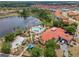 Community clubhouse with pool and playground sits on a lake, perfect for relaxation and recreation at 209 Rosso Dr, Davenport, FL 33837