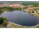 Scenic aerial view of a community lake and pool surrounded by lush greenery and homes at 209 Rosso Dr, Davenport, FL 33837