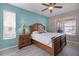 Bedroom showcasing blue walls, wood-look floors, a ceiling fan, and a large bed with a decorative headboard at 209 Rosso Dr, Davenport, FL 33837