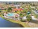 Aerial view of a community pool, playground, and lake surrounded by mature landscaping at 209 Rosso Dr, Davenport, FL 33837