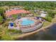 Aerial view of a community pool and clubhouse overlooking the lake and surrounding greenery at 209 Rosso Dr, Davenport, FL 33837