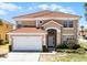 Two-story home featuring a red tile roof, attached garage, and well-maintained landscaping at 209 Rosso Dr, Davenport, FL 33837