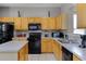 Traditional kitchen featuring wood cabinets, black appliances, and a tile floor at 209 Rosso Dr, Davenport, FL 33837
