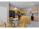 Bright eat-in kitchen with wood cabinets, black appliances, and a glass-topped breakfast table at 209 Rosso Dr, Davenport, FL 33837
