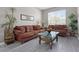 Cozy living room with hardwood-style flooring, couches, plants and large windows for natural light at 209 Rosso Dr, Davenport, FL 33837