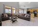 Bright living room area with open layout to kitchen, tile flooring, tall windows, and modern décor at 209 Rosso Dr, Davenport, FL 33837