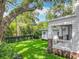 Side yard featuring a lush green lawn, framed by a dark wooden fence and mature landscaping at 217 W Bay St, Winter Garden, FL 34787