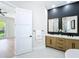 Modern bathroom featuring a dual sink vanity, stylish mirrors, and black accent wall at 217 W Bay St, Winter Garden, FL 34787