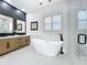 Bathroom with modern soaking tub, double sink vanity, and glass shower at 217 W Bay St, Winter Garden, FL 34787
