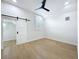 Bright bedroom with hardwood floors, modern fan and a barn door to the closet at 217 W Bay St, Winter Garden, FL 34787