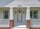View of the front entrance of the home with brick columns and modern lighting at 217 W Bay St, Winter Garden, FL 34787