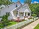 Charming exterior view with a white picket fence, landscaped yard, and inviting front porch with brick accents at 217 W Bay St, Winter Garden, FL 34787