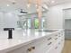 Open-concept kitchen island featuring a cooktop, light countertops, and seamless flow to the living area at 217 W Bay St, Winter Garden, FL 34787