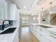 Well-lit kitchen featuring a dark faucet, white countertops, and an open view to the dining and living areas at 217 W Bay St, Winter Garden, FL 34787