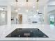 Stylish kitchen island with elegant pendant lighting, a cooktop, and an open view to the living area at 217 W Bay St, Winter Garden, FL 34787